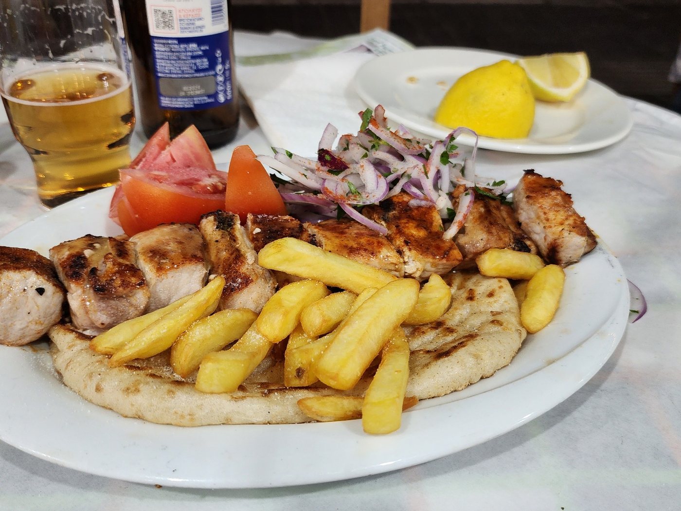 Grilled meat with chips, pita, tomato and onion